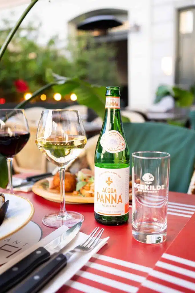 Bord med pizza, vin og mineralvand